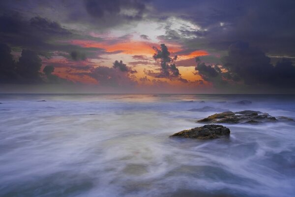 The surf at dawn is surrounded by fog