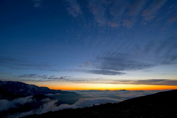 Zachód Słońca w górach nad niekończącymi się chmurami