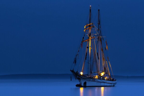 Navire dans les lumières dans la mer de nuit