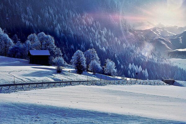 Hiver neigeux, maison solitaire au soleil