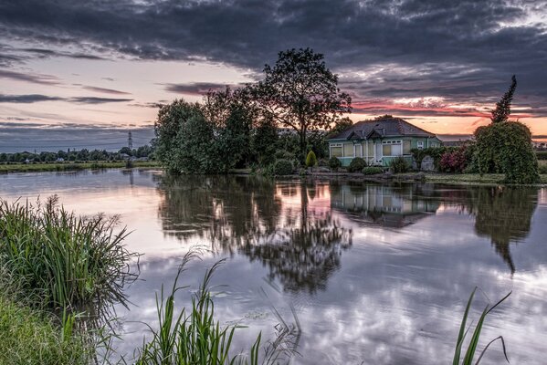 Domek nad wodą świt w fioletowych odcieniach