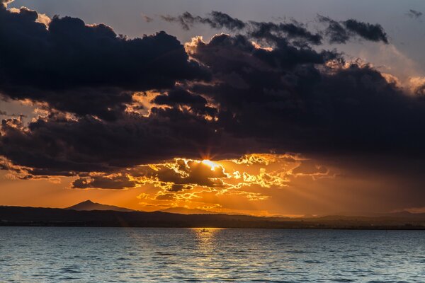 Lago en medio de la puesta de sol con nubes