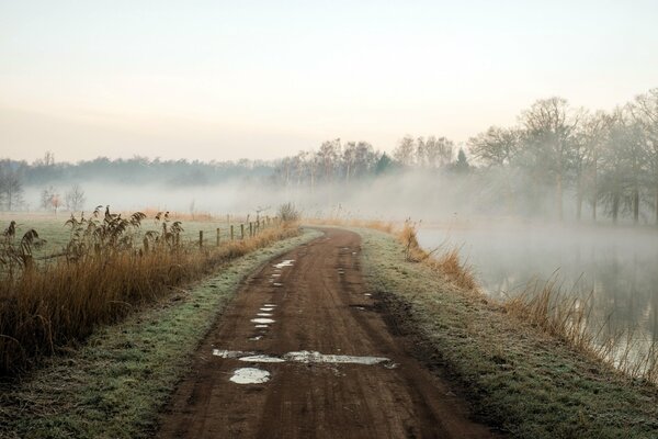 The road in the fog on the river bank