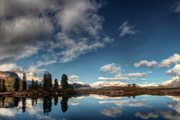 Panorama di riflessione di montagne e nuvole nel lago