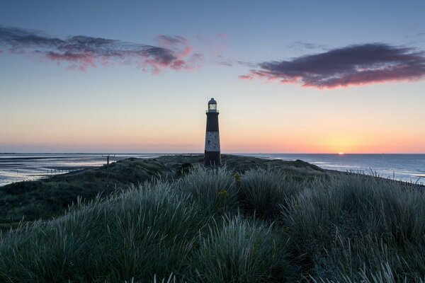 Phare sur la mer, au coucher du soleil de la journée