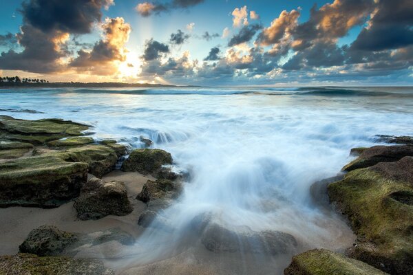 Puesta de sol en el mar con piedras