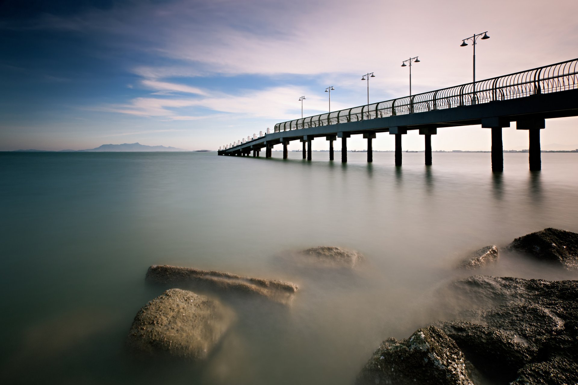 malesia mattina calma mare ponte molo riva pietre cielo nuvole