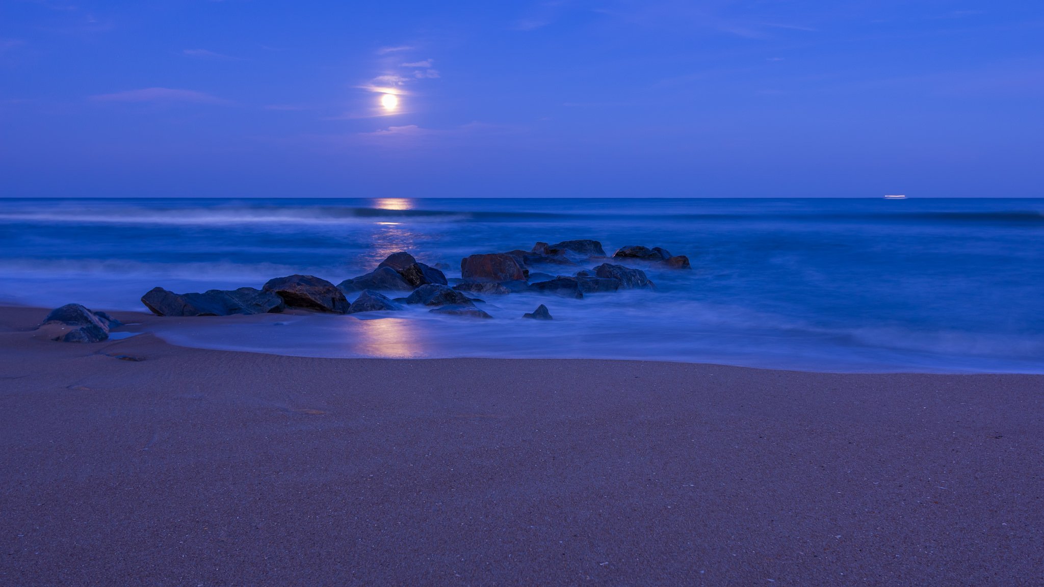 ozean küste strand sand steine nacht blau himmel wolken mond