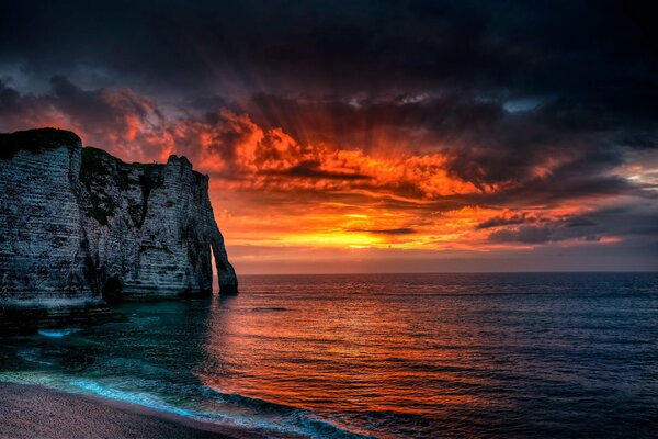 I raggi del sole si fanno strada attraverso le nuvole paesaggio marino