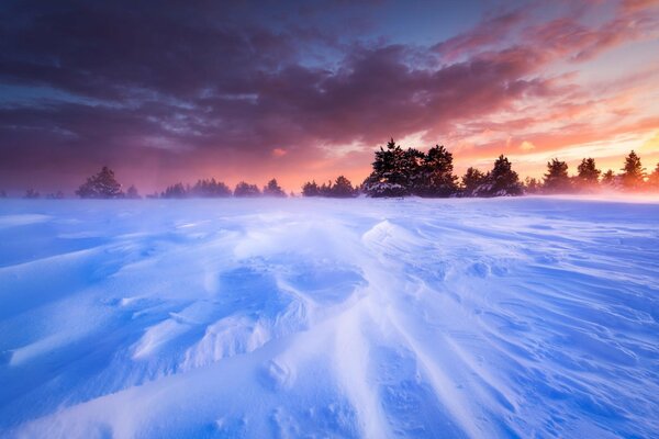 Verschneite Ebene auf Sonnenuntergang Hintergrund