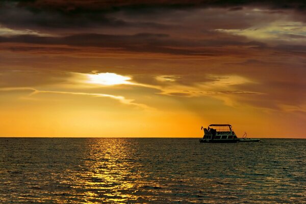 Navire sur la mer sur fond de coucher de soleil