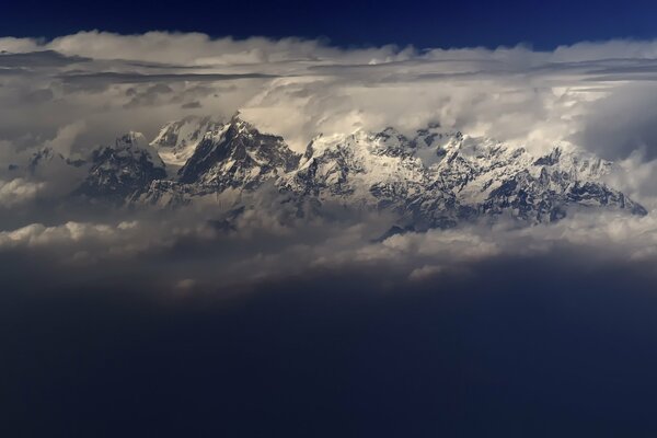 Montagnes dans les nuages, ciel bleu