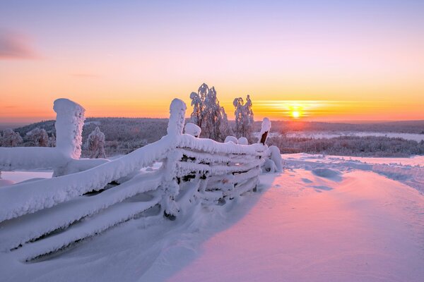 Landschaft mit Zaun auf Winter Sonnenuntergang Hintergrund