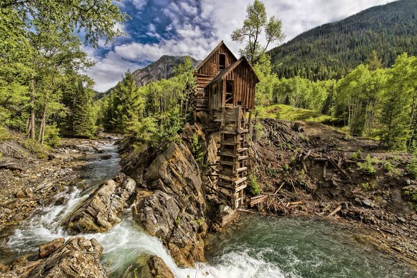 Eine alte Mühle auf einem Berg in der Nähe eines Wasserfalls